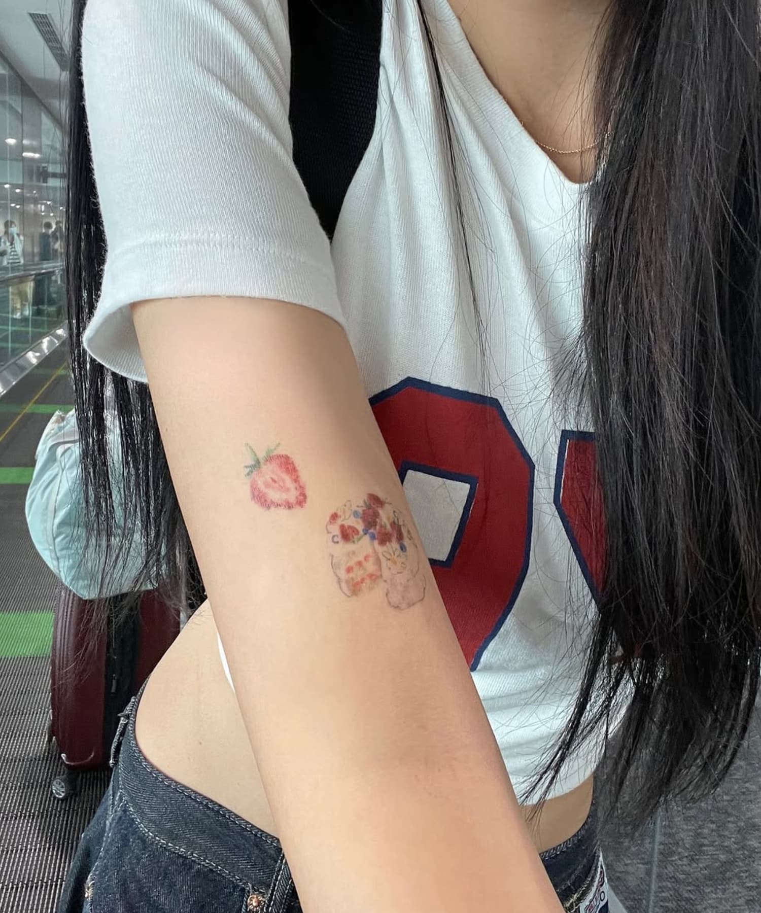 腕にタトゥーステッカーを貼ったZ世代の女の子(いちご&スイーツ柄)